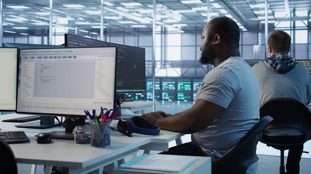 Engineer writing code and doing checkup on server room