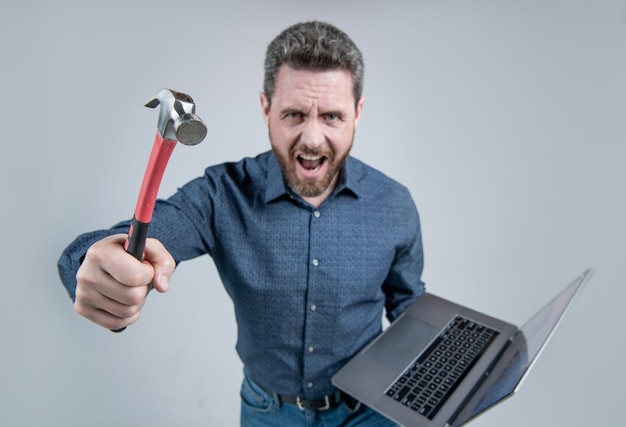 Failed to complete a task Angry man shout holding hammer and laptop Computer rage Feeling angry Anger and frustration Malware or computer viruses Software issues Operating system crash