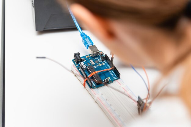 Female College Student Building Machine In Science Robotics Or Engineering ClassStem educationCloseup