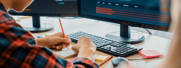 Female programer taking a note while young skilled web developer present program while computer displayed program code at modern office company Java script web design concept Burgeoning