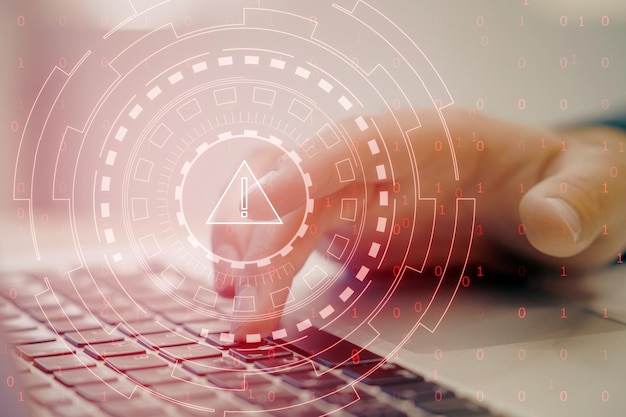 Finger pressing a keyboard with digital warning symbol overlay indicating cybersecurity threat