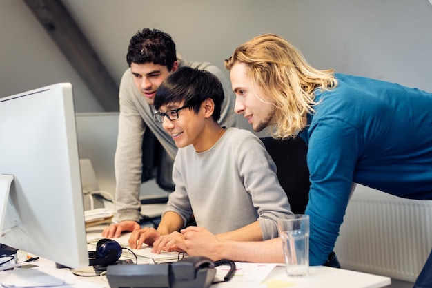 Forretningsfolk, der bruger computer ved skrivebord på kontoret