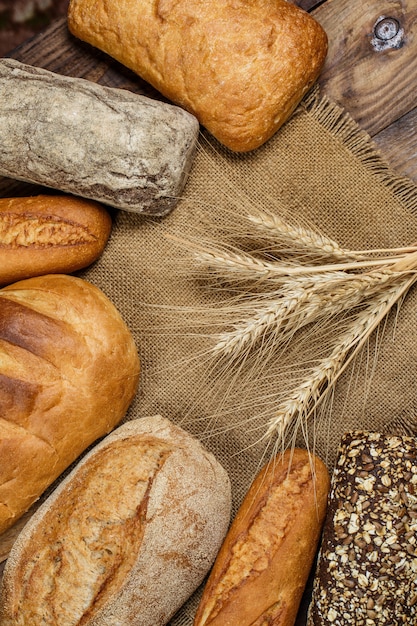 Fresh crispy bread with flour on a wooden table
