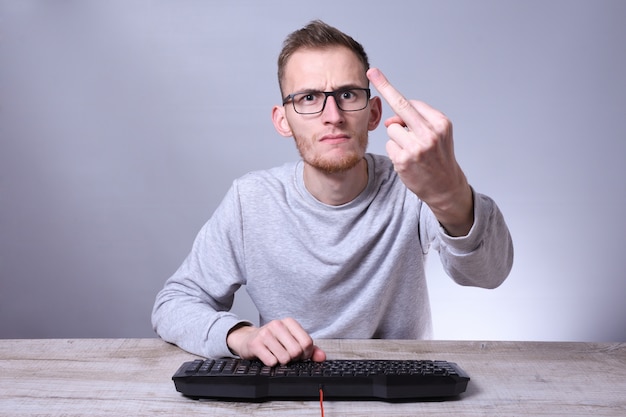 funny nerd young businessman, man working on computer.typing on the keyboard programmer in glasses in front of computer.