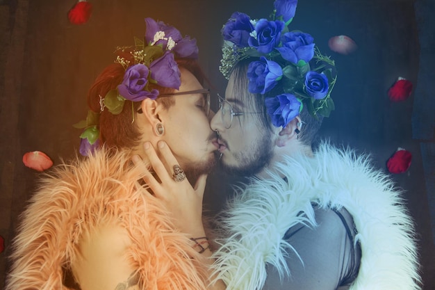 gay couple wearing flowers and feather boa while kissing