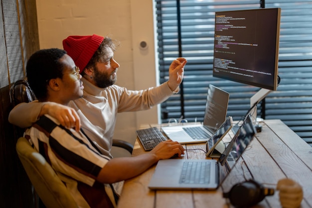 Gay couple working on computers at home office