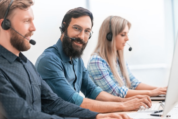 Group of specialists in the headset working on computers