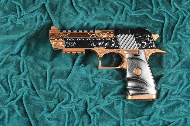 Gylden pistol på grøn fløjl