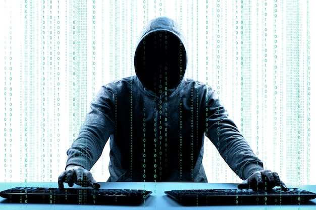 Hackare skriver ut en kod på ett tangentbord för att ta sig in i ett cyberspace