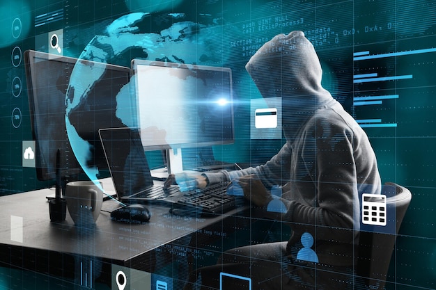 hacker at desktop with monitors using laptop with creative glowing globe hologram grid interface on blurry background digital transformation hacking innovation and future concept double exposure