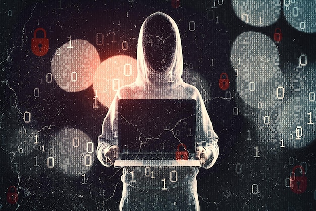 Hacker in hoodie showing laptop while standing on abstract dark hacking background with bokeh circles and binary coding Malware and phishing data theft concept