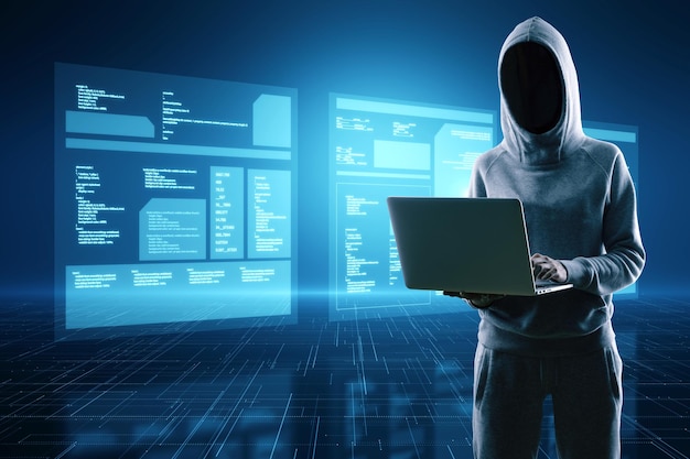 Hacker in hoodie using laptop computer with digital database folded on blurry blue background with reflections Digital transformation hacking data theft and media concept
