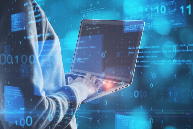 Hacker in hoodie using notebook with abstract glowing blue coding background Binary code theft technology data and internet concept Double exposure
