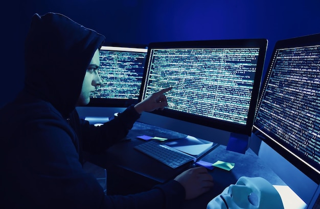 Hacker using computer in dark room