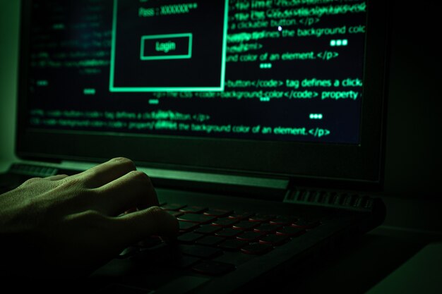 Hacker using laptop into dark web.