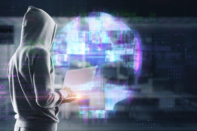 Hacker using laptop with abstract digital skull hologram on blurry office interior background Hacking malware and phishing concept Double exposure