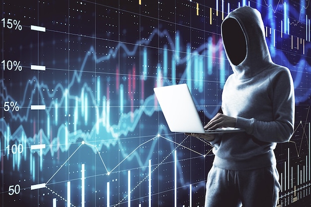 Hacker using laptop with glowing stock chart