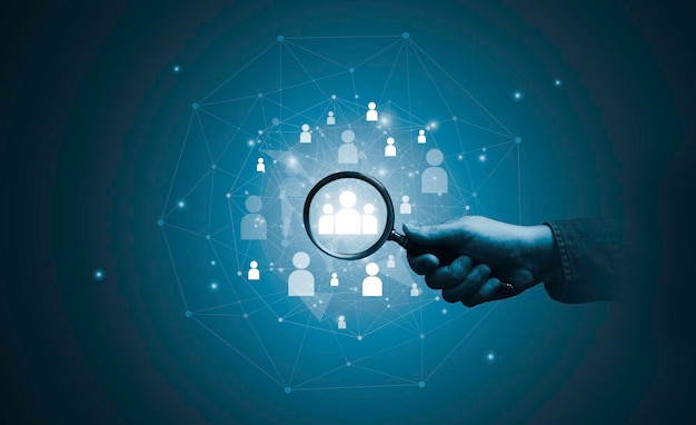 Hand holding magnifier glass with human icon for focus customer target of customer relation management or CRM and human development concept