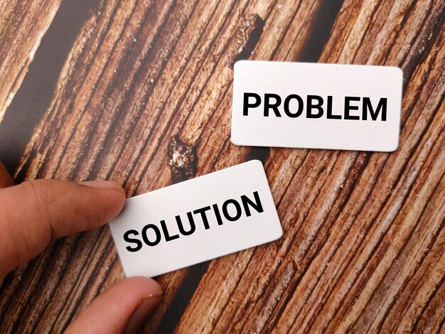 Hand som håller träskiva med texten "PROBLEM SOLUTION" på träbakgrund