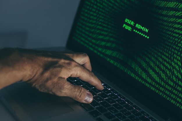Hand typing on a laptop keyboard green numbers on display successful login with user and password