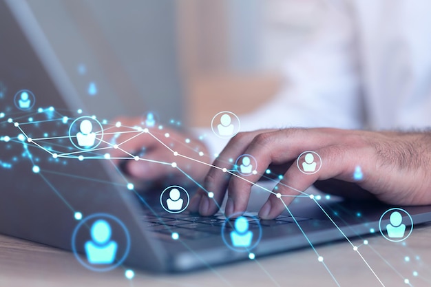 Hands of hr specialist is typing the keyboard in the internet to find the best candidates to create international network in recruitment process Formal wear Social media hologram icons