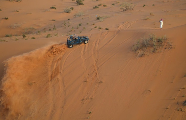 High angle view of man and off-road vehicle at desert