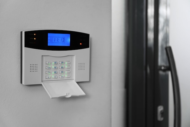 Home security system on white wall indoors space for text