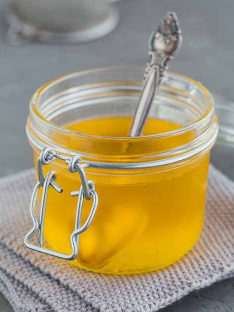 homemade ghee or clarified butter in jar on grey concrete table
