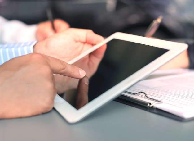 Image of human hand pointing at touchscreen in working environment at meeting