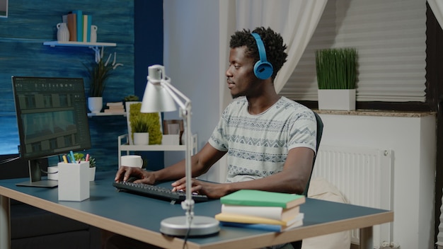 Ingeniør med hovedtelefoner skaber bygningsmodel på computer