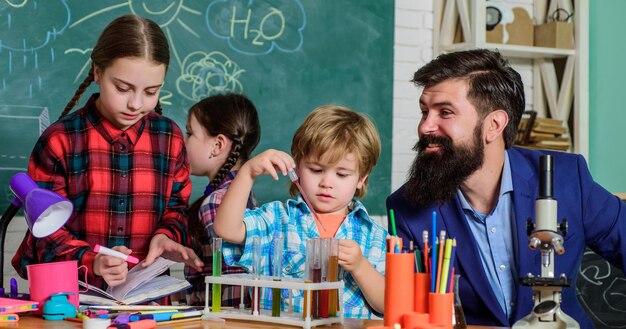 Inspire Science and education chemistry lab back to school happy children teacher children making science experiments Education doing experiments with liquids in chemistry lab