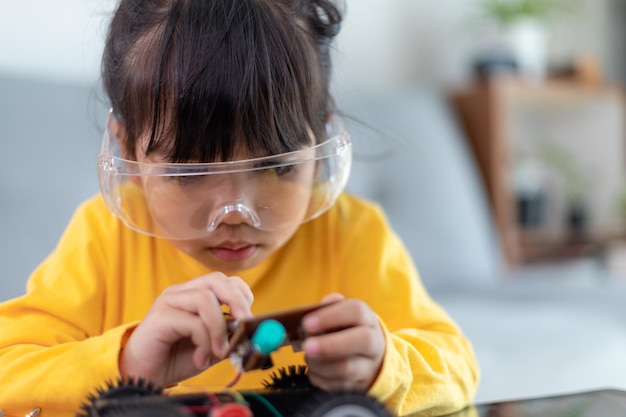 Inventive kid constructing robot cars at home