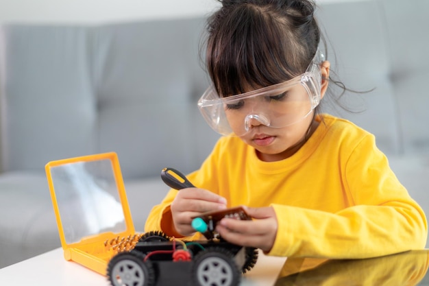 Inventive kid constructing robot cars at home