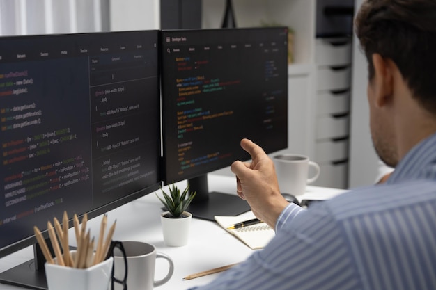 IT developer man pointing information center on laptop at back side Postulate