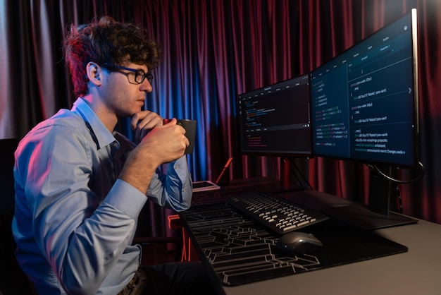 IT developer thinking online software and holding coffee cup Gusher
