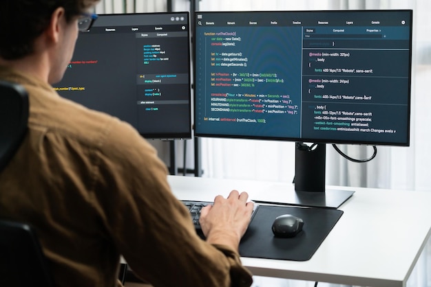 IT developer working online software development coding on pc screens Gusher