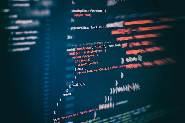 Körning av datorinformation/WWW-programmering. Kodningsskripttext på skärmen. Närbildsfoto av bärbar dator.