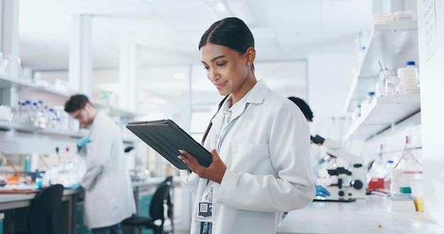 laboratory woman and science with tablet for research medical diagnosis and results with tech female biologist connection and online info for reading analysis and digital for problem solving