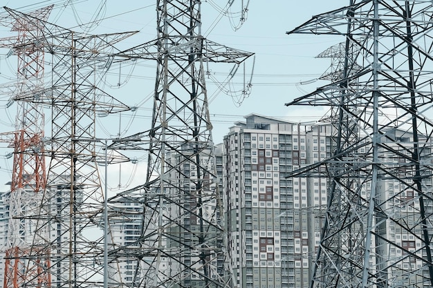 Low angle view of electricity pylons against buildings