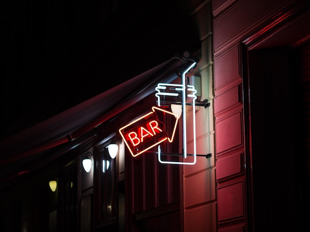 Low angle view of illuminated bar sign at night