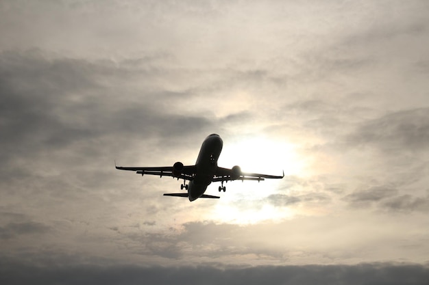 Low angle view of silhouette airplane flying against sky
