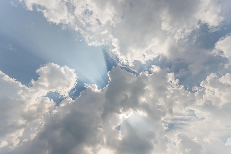 Bild low angle view of sunlight streaming through clouds