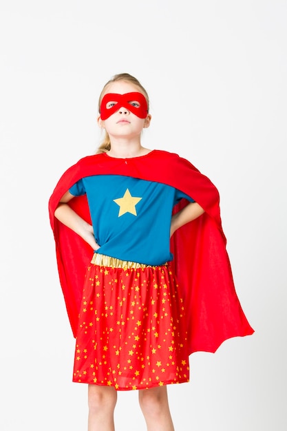 Low section of child standing against red background