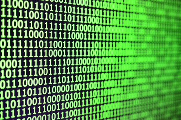 Makrobillede af binær kode på skærmen på en kontorcomputer.