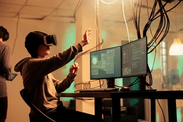 Male hacker using vr glasses to hack computer system planting trojan virus for malware at night Young adult working with 3d virtual reality on headset modern technology hacking