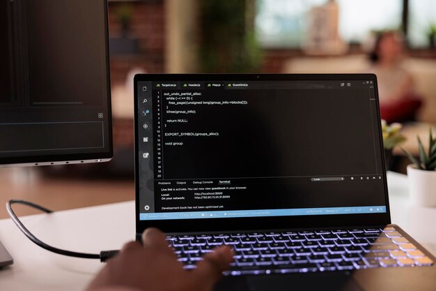 Male programmer using coding encryption interface app on laptop screen, working with binary code and cloud server. Coder programming security firewall on terminal window. Close up.