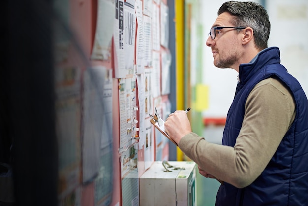 Man business and board for checking schedule or calendar for shipping details supplier information and warehouse Guy notice or clipboard and thinking for orders or inventory poster and notes