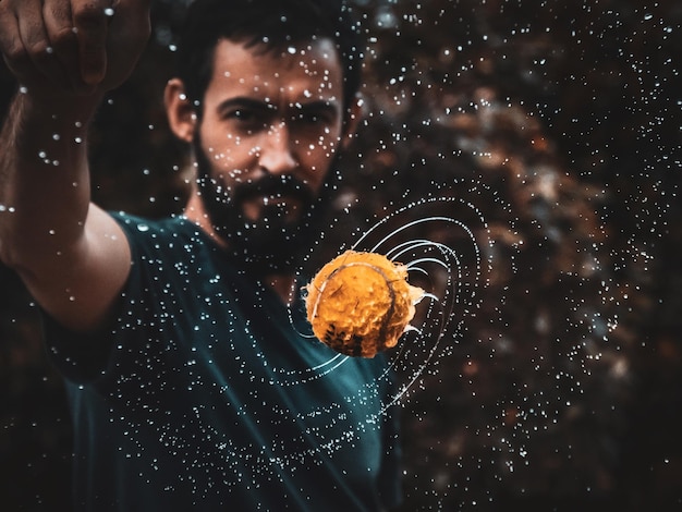 Man by wet tennis ball in mid-air