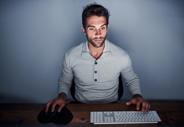 Man computer and working at night with keyboard in house for design software and creative Web designer technology and remote work late in home for website internet and programming with desk