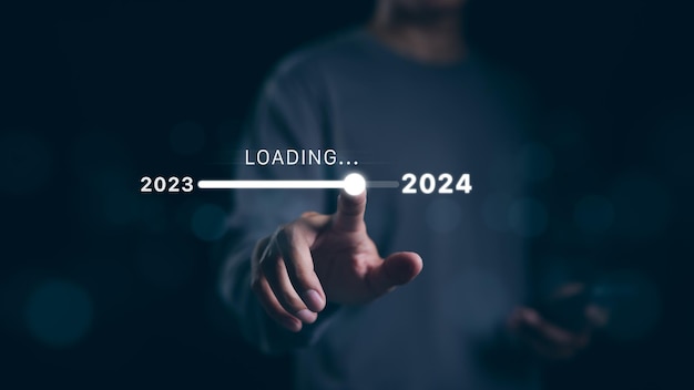 Man hand touching loading bar for countdown to 2024 In progress loading year 2023 to 2024 Planning and challenge business strategy in new year Countdown merry Christmas and Happy New Year Startup